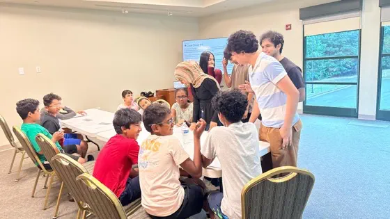 A group of students gathered around a table discussing a case study