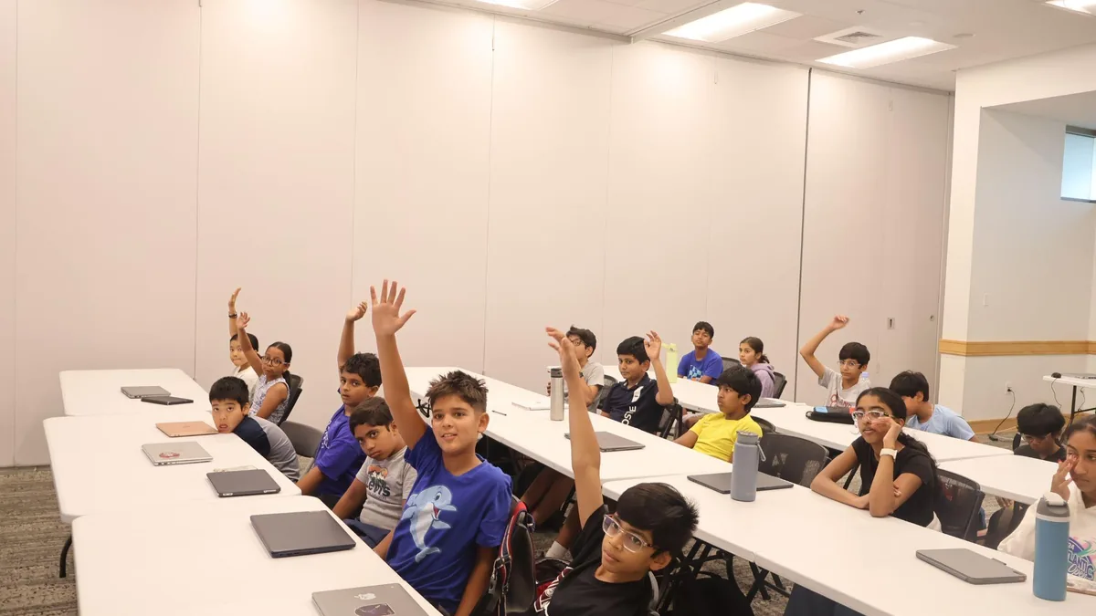 Students raising their hands during a classroom activity