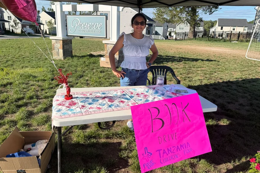 A book drive collection table set up at a neighbourhood entrance
