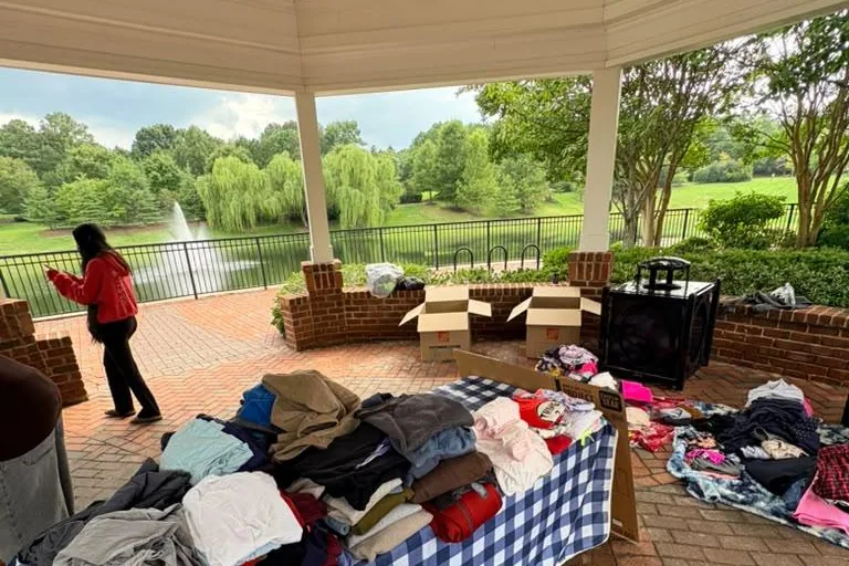 Volunteers sorting clothing at trestle tables under the pavilion