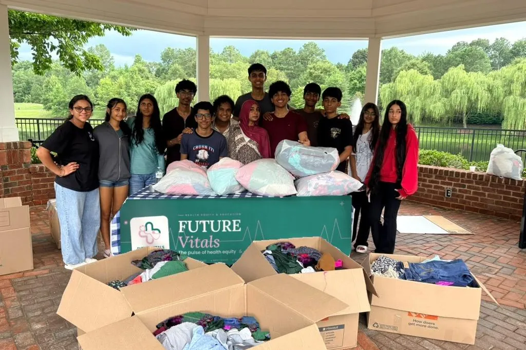 FutureVitals volunteers with collected clothing and the organization banner