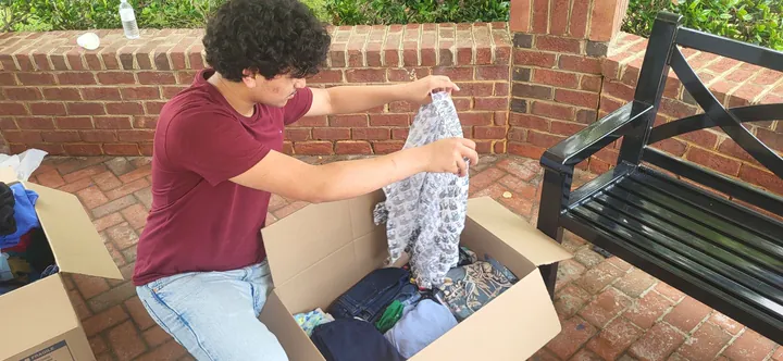 A volunteer packing a sorted box of clothing