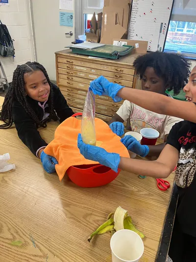 Students in gloves working through a hands-on experiment
