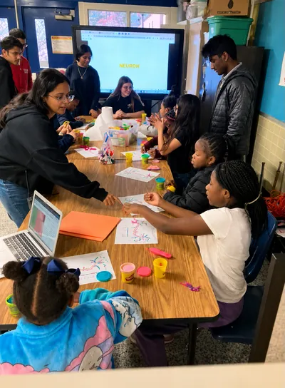 Students working with modeling clay at a classroom table