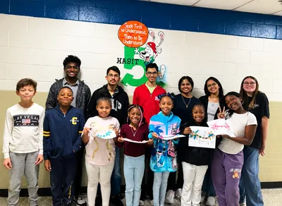Volunteers and students holding up the neuron models they made