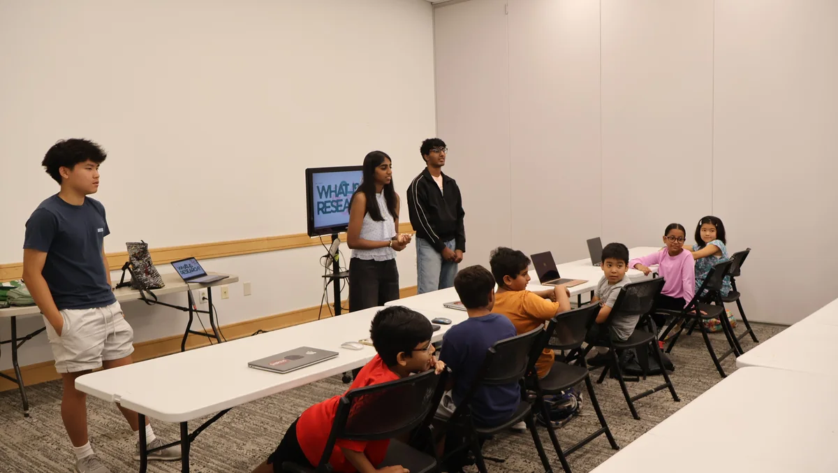 Students at a FutureVitals workshop listening to a presentation titled What Is Research